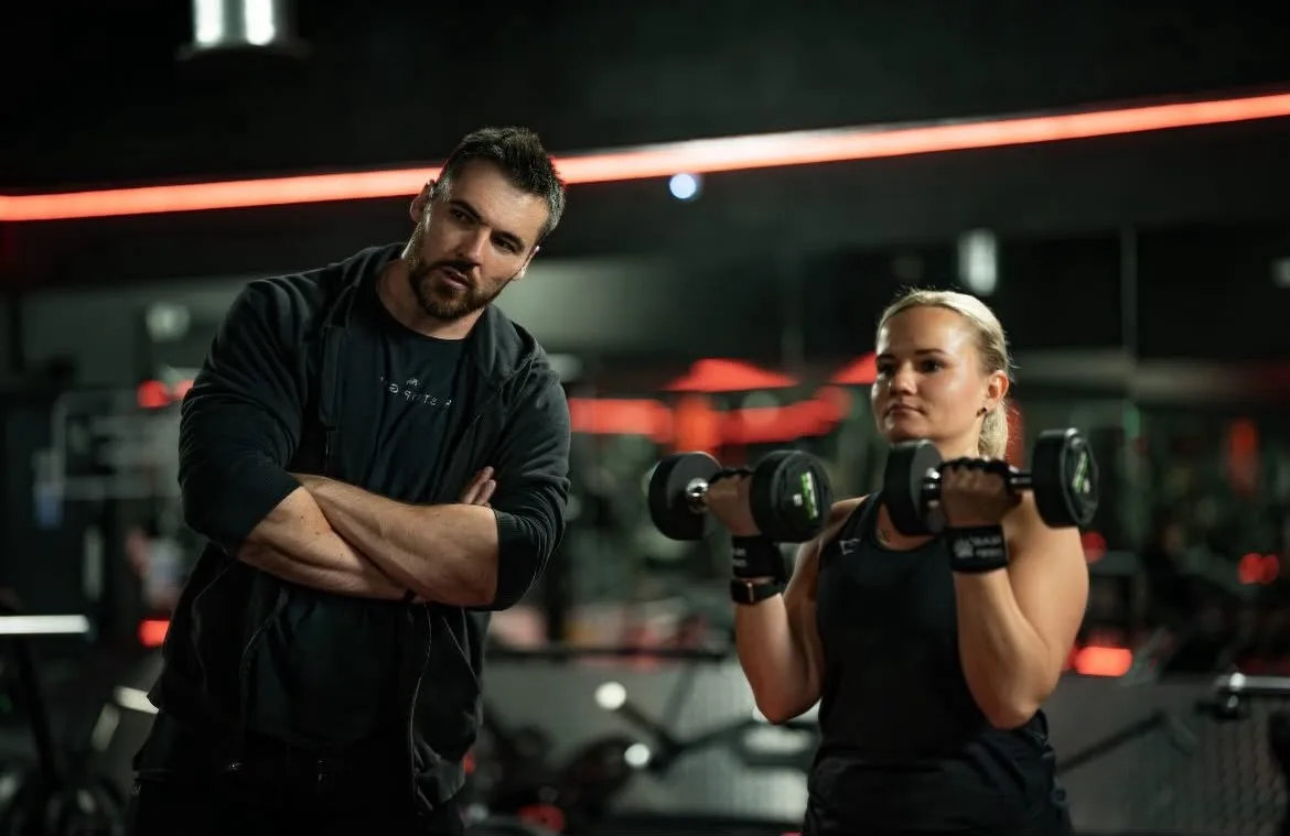 Dan training a client through a dumbbell session